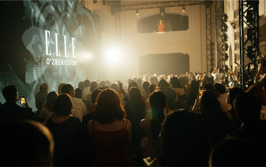 Crowd at the ELLE Oʻzbekiston launch event, filming the stage and the logo on a large screen